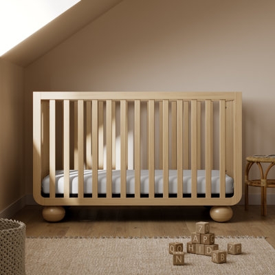 Transitional Convertible Crib featuring Arched Back Rail in Nursery Setting
