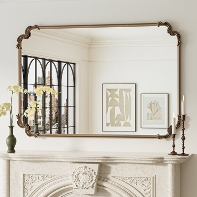 Ornate Wall Mirror featuring antique silver scrollwork frame and crest