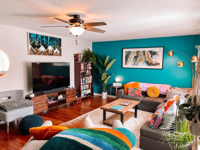 Maximalist Living Room Idea: Teal Accent Wall and Forest Green Sectional