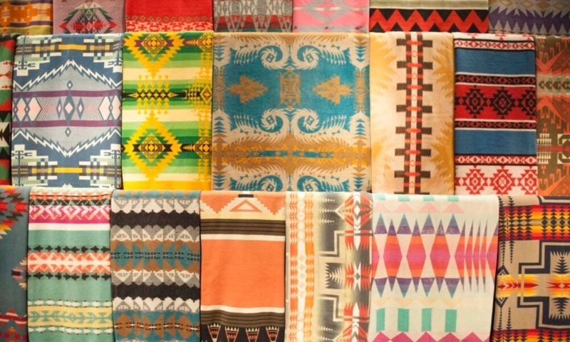 Stacked Woven Throw Blankets with Earthy Tone Southwestern Motifs