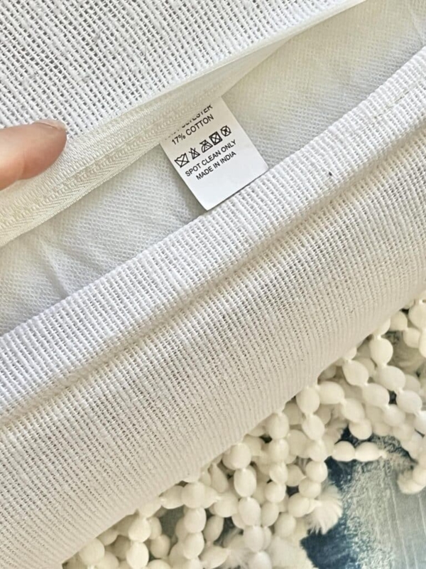 Throw Pillow Light Gray Woven Fabric showing Spot Clean Care Tag