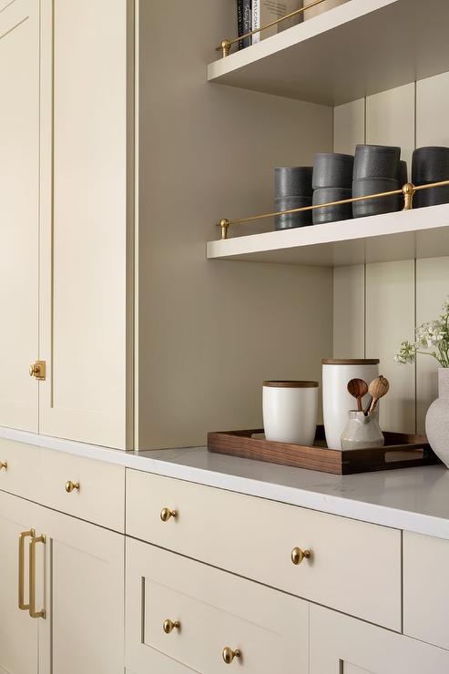 Kitchen Cabinetry: Light Beige Shaker Style with Oval Brass Knobs