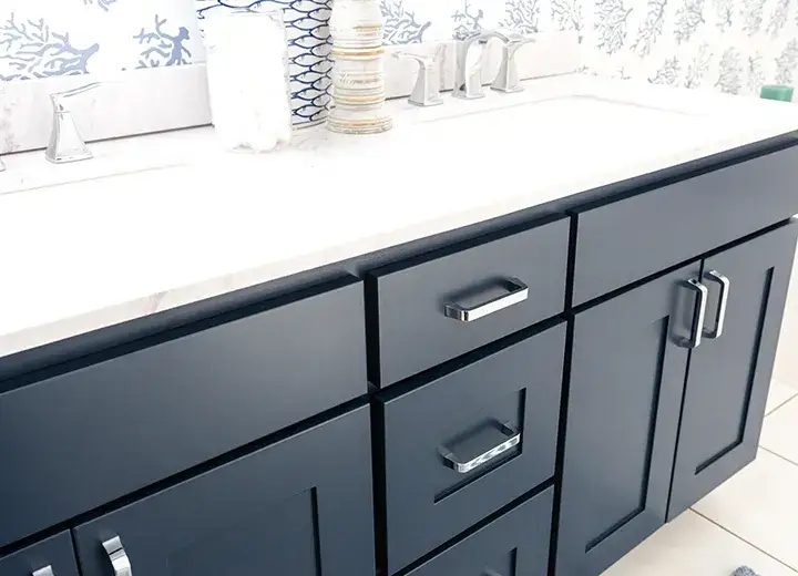 Navy Shaker Cabinet Doors: Slim Gold Hardware and Vertical Tile Backsplash.