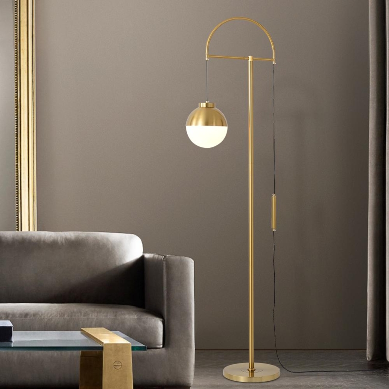 Floor Lamp with globe shade, arc silhouette, and gold finish.