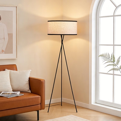 Modern Tripod Floor Lamp Design: Slender Legs, Off-White Drum Shade.