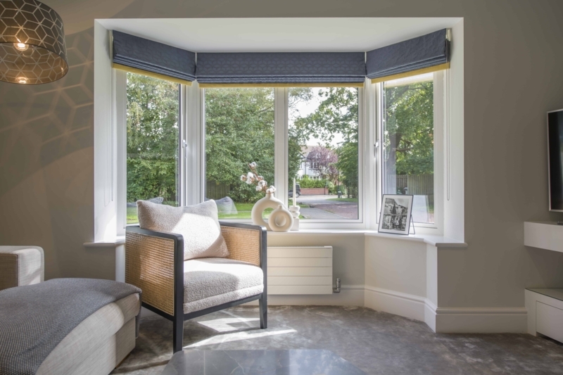 Accent Chair with Cane Sides in a Bay Window Nook with Blue Shades