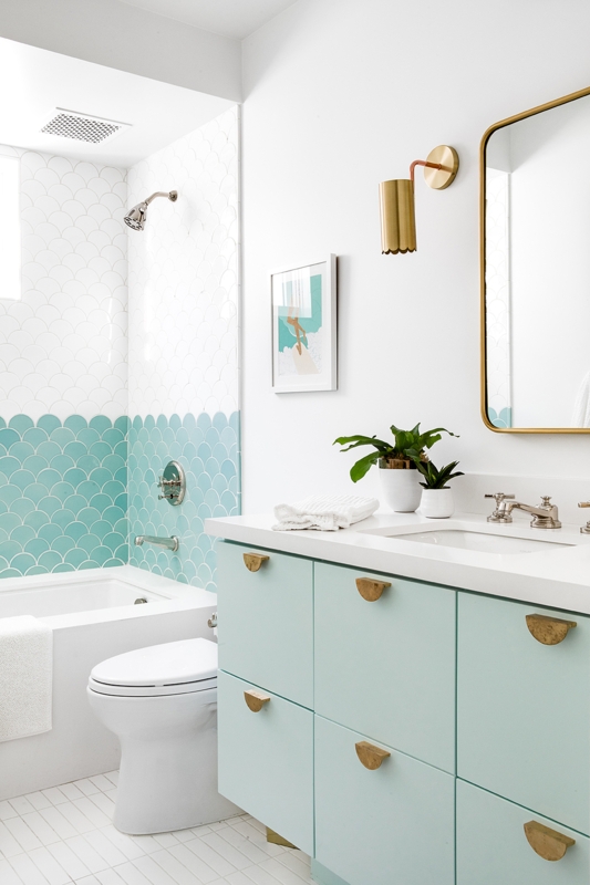 Airy Coastal Bathroom with mint scalloped wall tile and brass hardware.