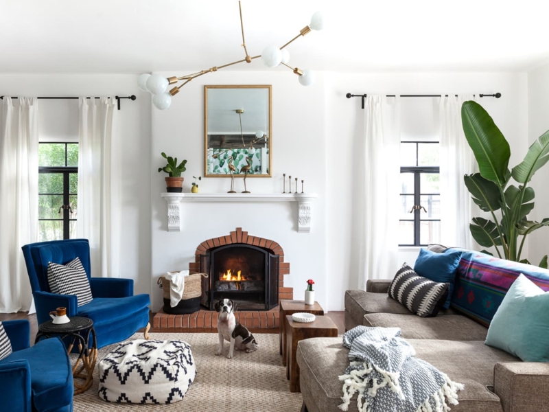 Airy Living Room With Brick Fireplace And Blue Velvet Chairs