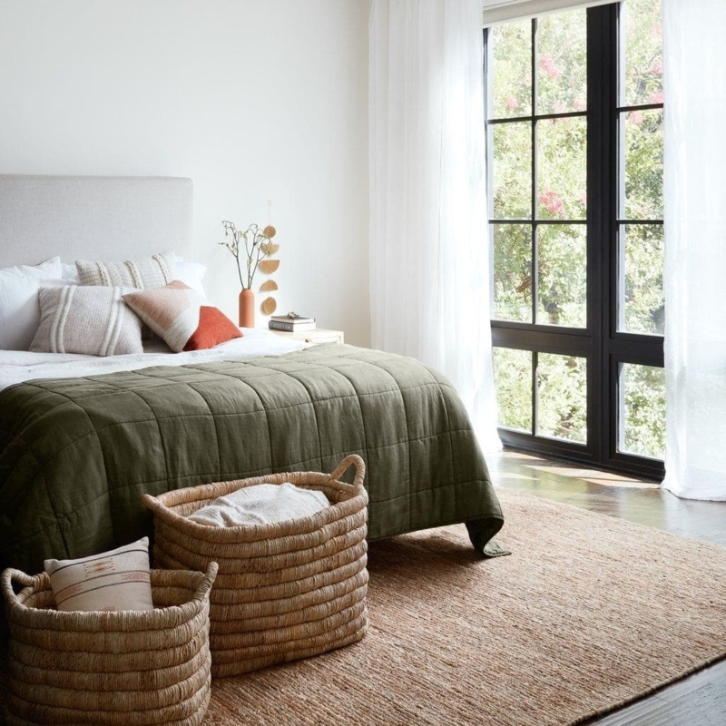Area Rug: Large Natural Jute placed under Bed with Olive Quilted Bedding.