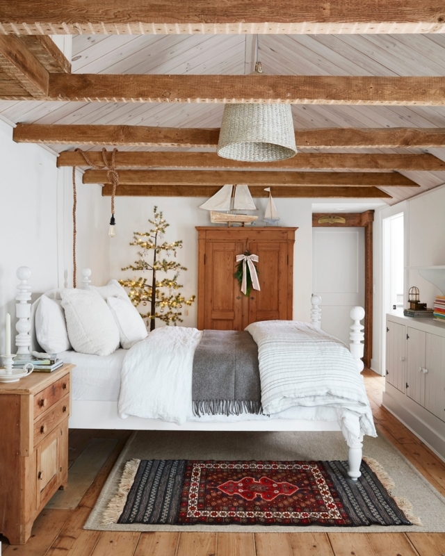 Area Rugs Layered in Rustic Attic Bedroom with Exposed Beams.