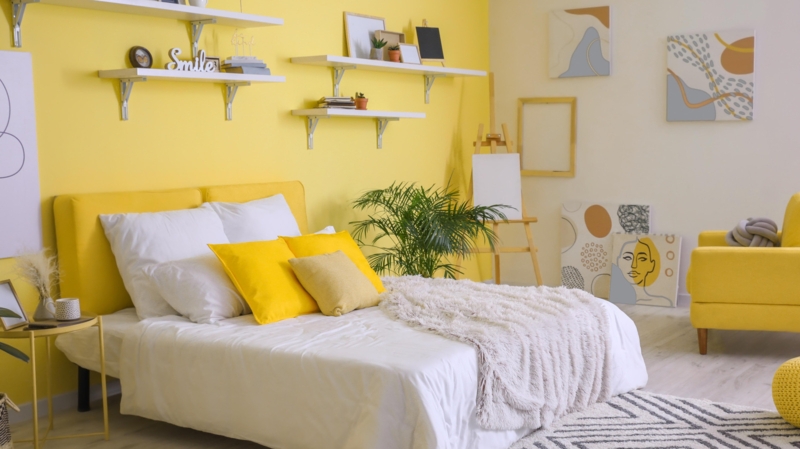 Artistic Bedroom with Yellow Accent Wall and Easel