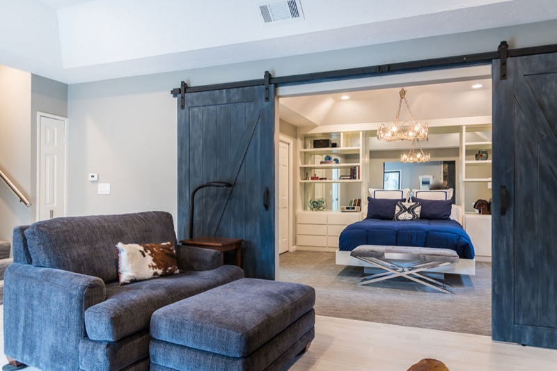 Basement Living Suite with Blue Barn Doors and Built-In Bedroom Storage