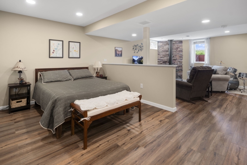 Basement Suite with Half Wall Partition and Stone Fireplace Accent