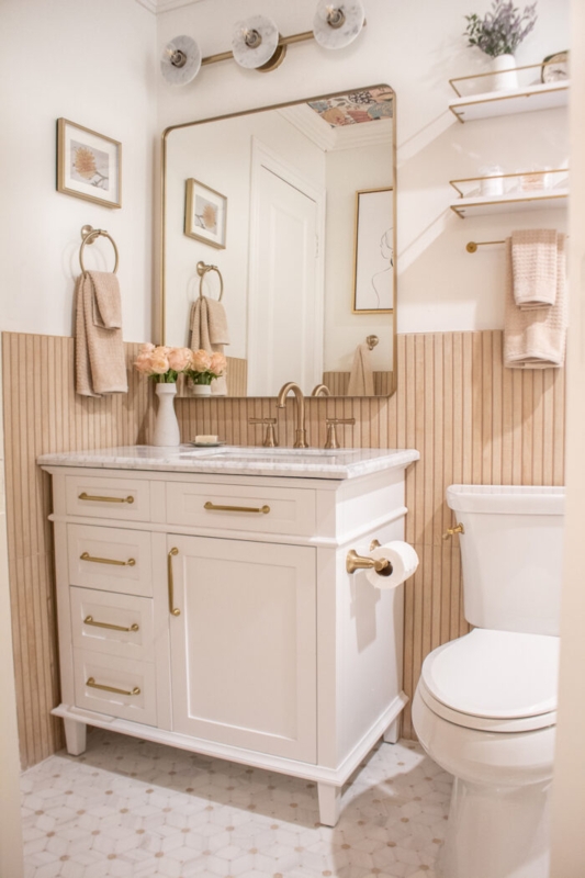 Bathroom Vanity with ribbed wood paneling and gold hardware accents.