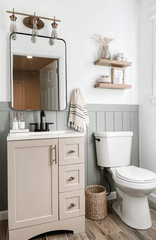 Bathroom Vanity with Sage Green Wainscoting and Bronze Light