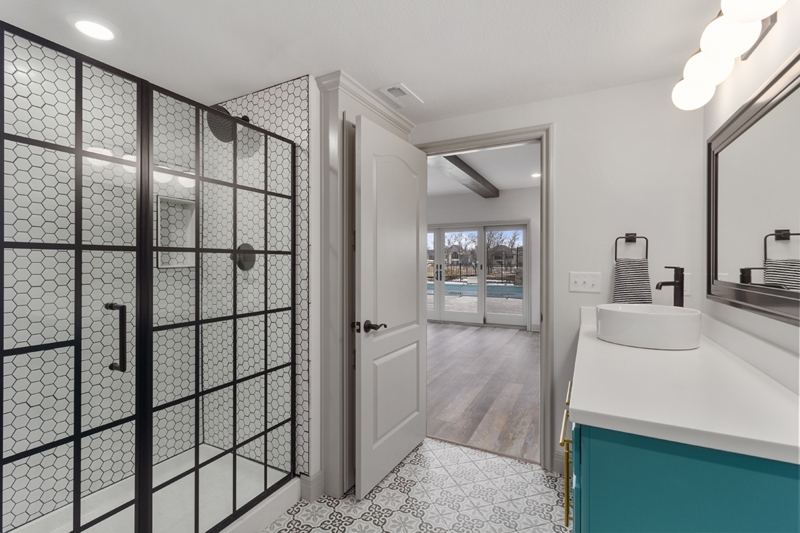 Bathroom with Teal Vanity Design and Black Grid Shower Enclosure