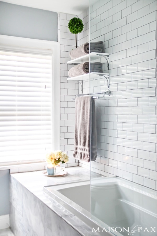 Bathroom with White Subway Tiles, Glass Partition, and Floating Shelves