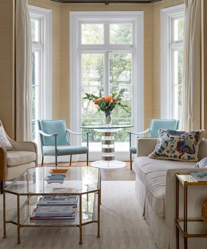 Bay Window Layout with Glass Tiered Coffee Table and Blue Accents
