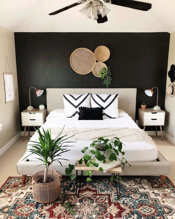 Bed against Black Accent Wall with Woven Wall Decor & Chevron Pillows