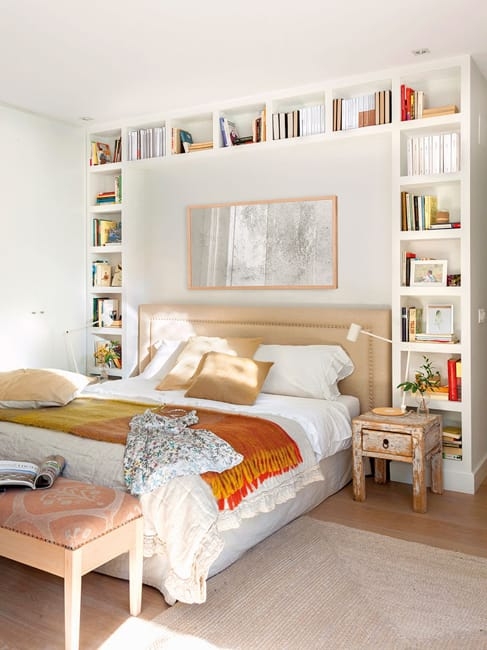 Bed Framed by White Built-in Bookshelf Storage System