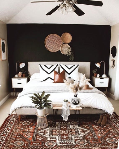 Bed in Boho Bedroom with Black Wall, Woven Wall Baskets, Geometric Rug