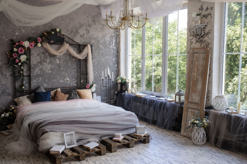 Bed Pallet Frame with Tulle Ceiling Drapery and Distressed Wall