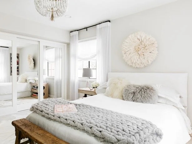 Bed with Chunky Knit Throw, Juju Hat Wall Art, and Mirrored Closet Doors
