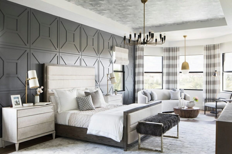Bed with Geometric Wall Paneling and Curved Lounge Sofa Seating Area