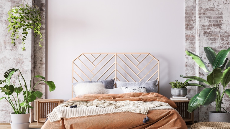 Bed with Gold Geometric Headboard and Terracotta Bedding against Brick Wall