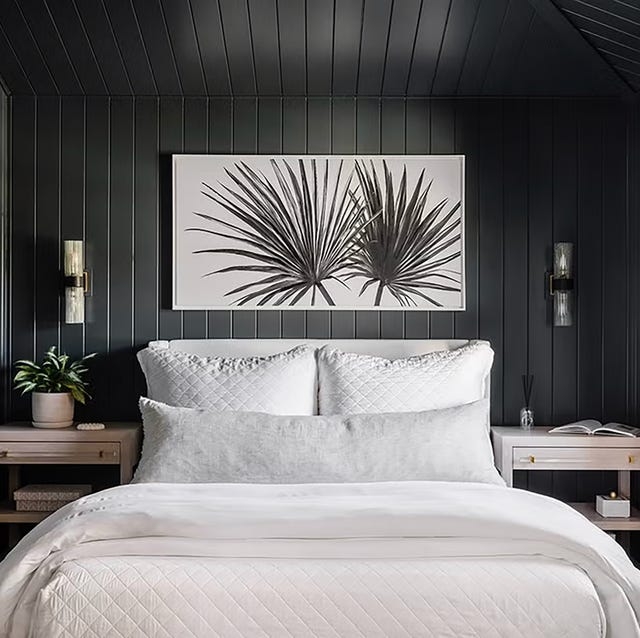 Bed with Oversized Lumbar Pillow against Dark Slatted Walls