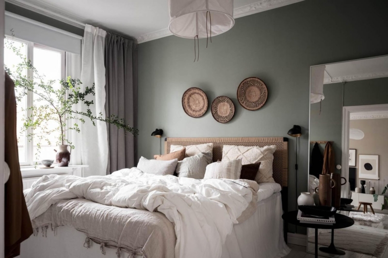 Bed with Rattan Headboard and Woven Basket Art on Sage Green Walls