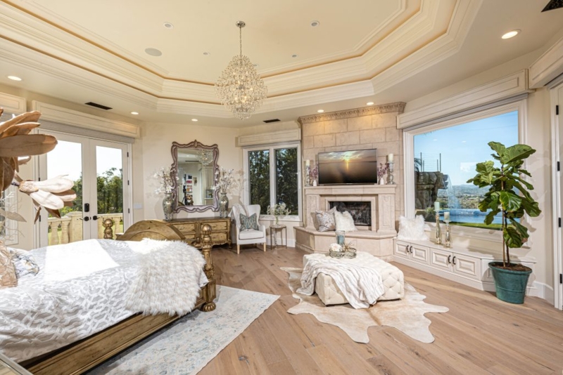 Bed with Stone Corner Fireplace in Master Bedroom with View Window
