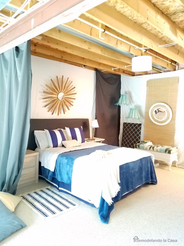 Bed with Sunburst Mirror, Exposed Joists, and Navy Coastal Decor