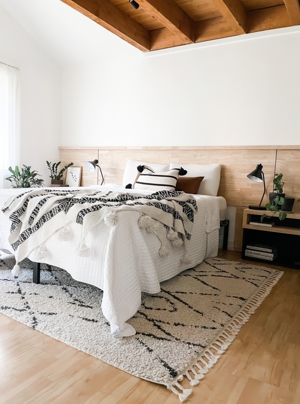 Bed with Tasseled Shag Rug, Exposed Wood Beams, Wood Ledge Headboard