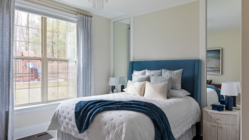Bed with Teal Winged Headboard and Mirrored Wall Panels