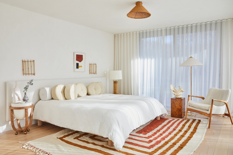 Bed with Terracotta Geometric Rug and Wall-to-Wall Sheer Curtains