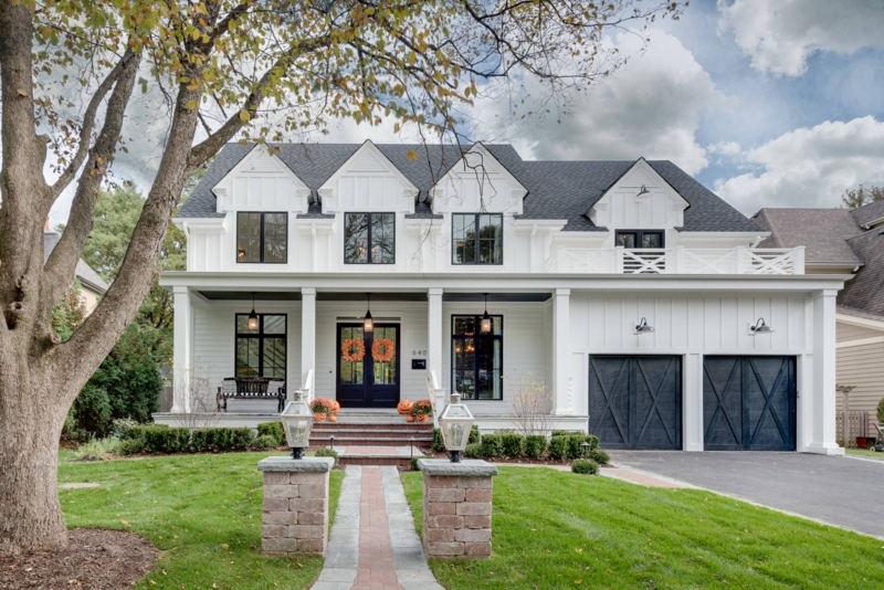 Black Garage Doors with Cross-Bracing on Triple Gable Farmhouse