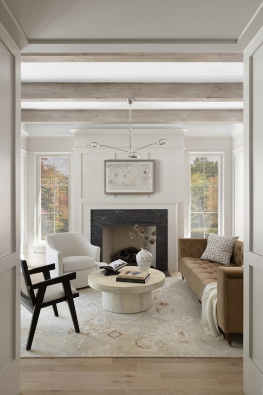 Black Marble Fireplace with Exposed Wood Beams and Tufted Sofa
