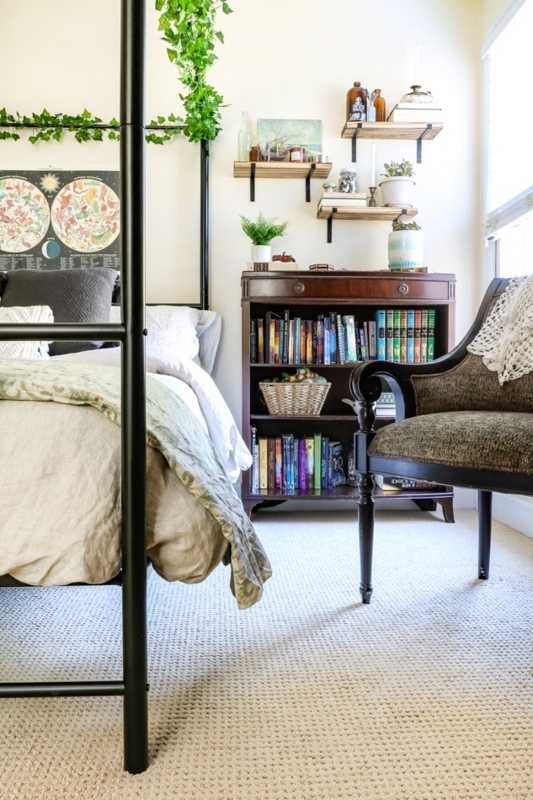 Black Metal Canopy Bed with Hanging Vines and Celestial Wall Art