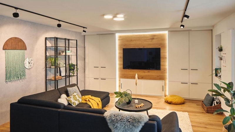 Black Track Lighting and Backlit Wood Panel TV Wall