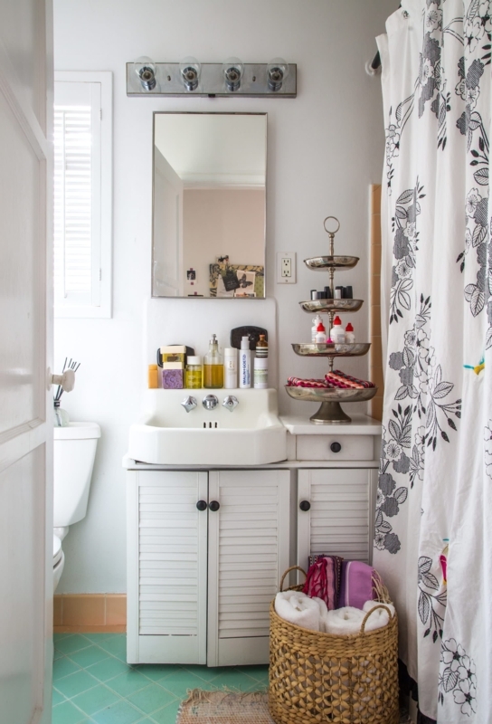 Boho Bathroom with Teal Tile Floor and White Louvered Vanity Cabinet