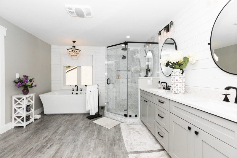Bright Farmhouse Bathroom with Black Framed Glass Shower and Round Mirrors