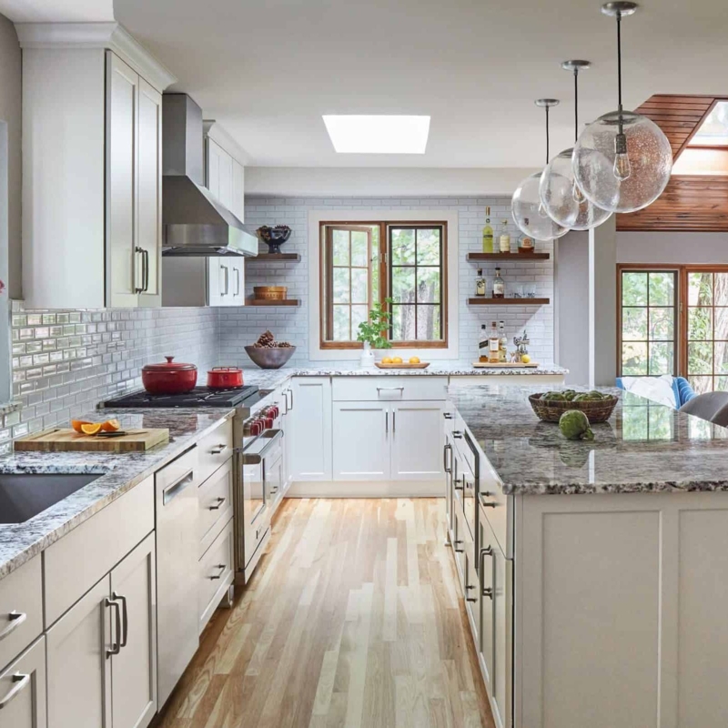 Bright Kitchen with Skylight, Granite Island, and Glass Subway Tile