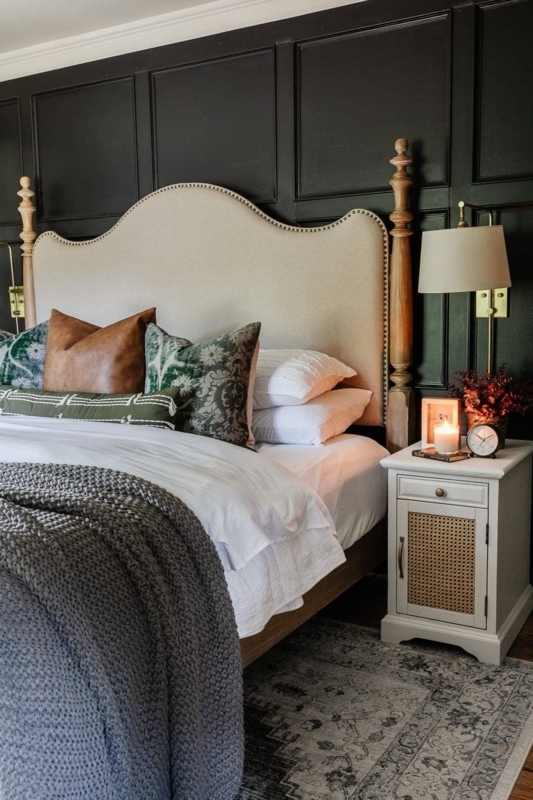 Camelback Headboard with Nailhead Trim against Black Paneled Wall