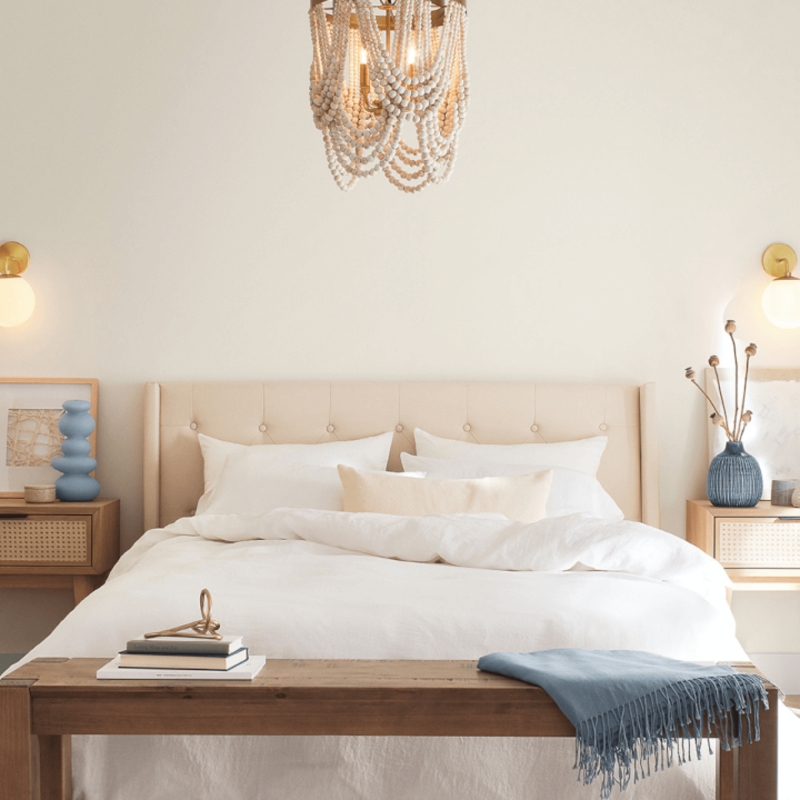 Cane Nightstands and Beaded Chandelier in Coastal Eclectic Bedroom