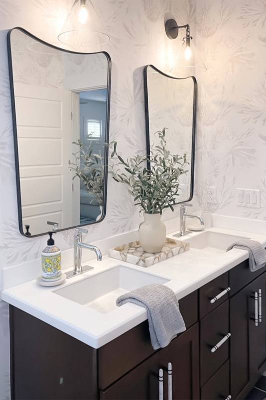 Charcoal Double Vanity with Curved Black Mirrors and Botanical Wallpaper