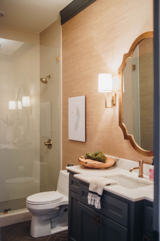 Chic Guest Bathroom with Grasscloth Walls and Scalloped Gold Mirror