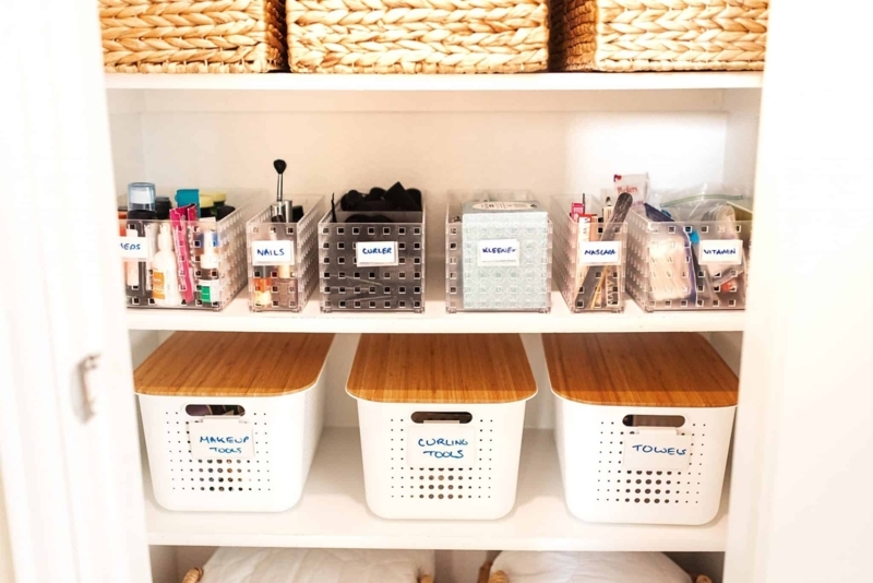 Closet Organization bins with bamboo lids and clear grids. SEO: minimalist bathroom linen closet.