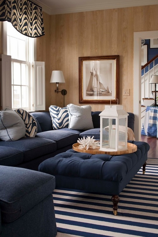 Coastal Navy Sectional with Wood Paneled Walls and Tufted Ottoman