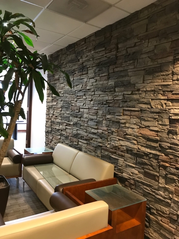 Contemporary Office Lounge with Stacked Stone Wall and Modular Seating